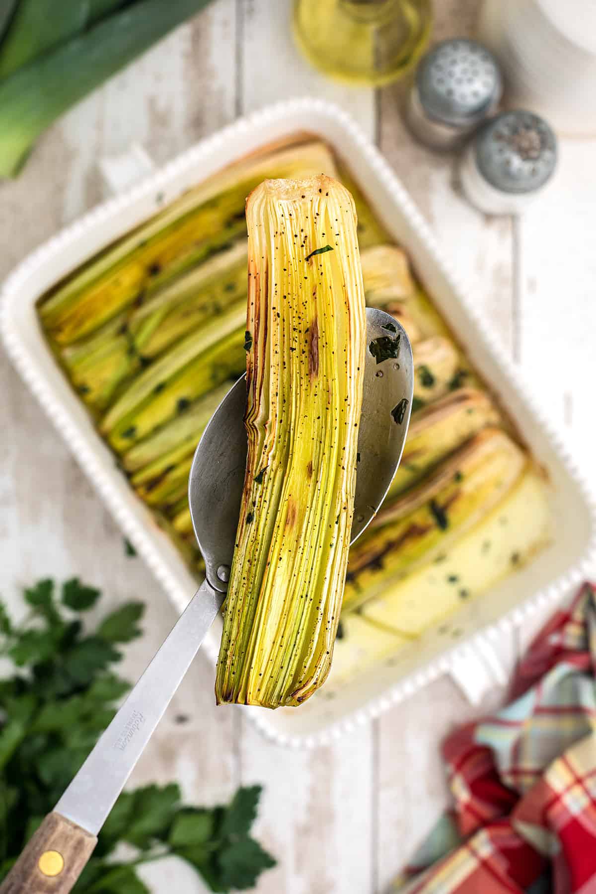 Roasted leeks in a baking dish.