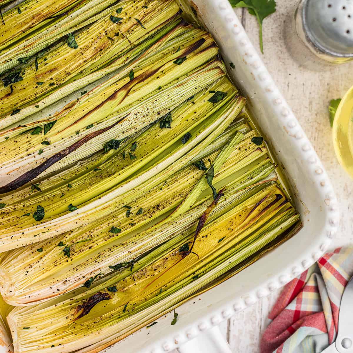 Roasted leeks in a baking dish.