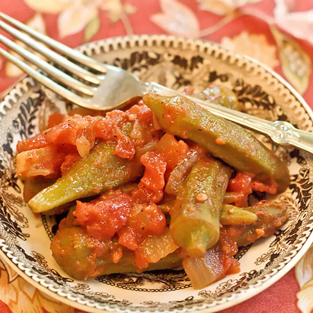 Stewed okra and tomatoes in a small dish with a fork on the side.