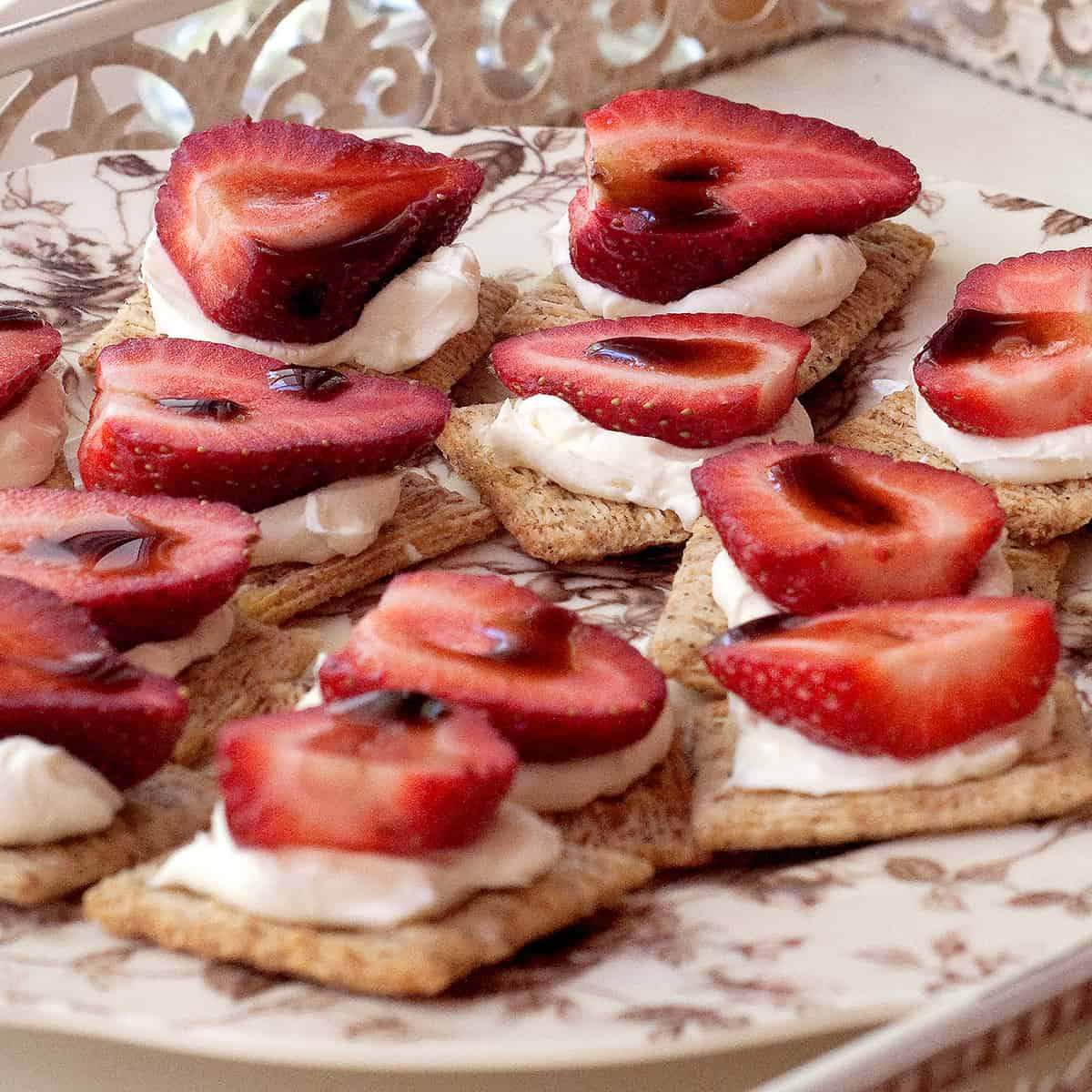 Strawberry slices with balsamic vinegar and cream cheese on crackers.