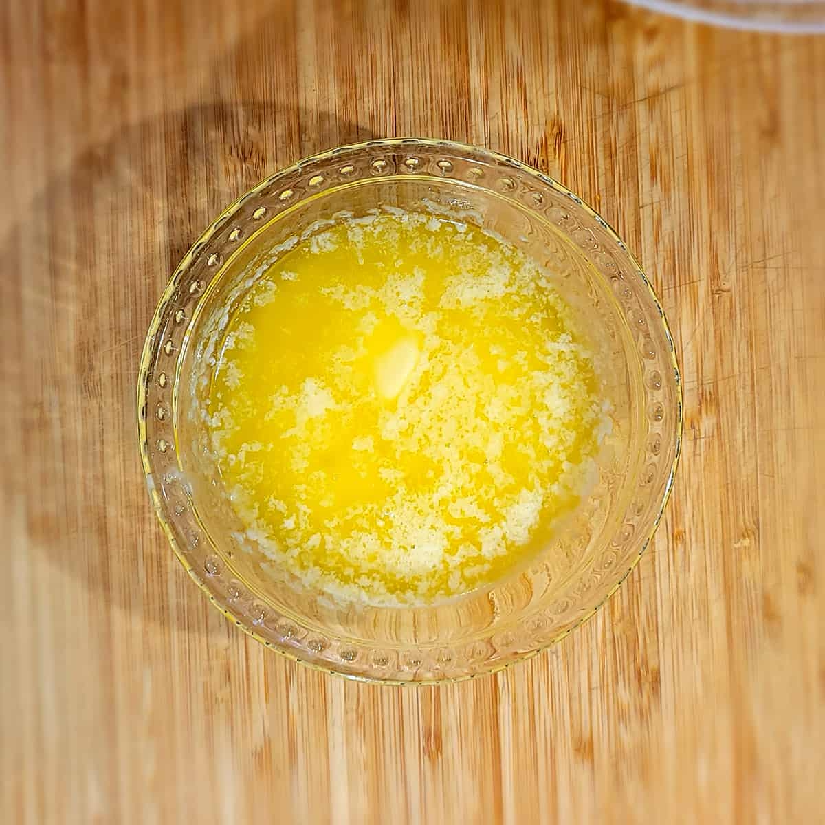 Melted butter in a small bowl.