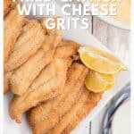 Golden fried catfish fillets with lemon wedges, served on a plate next to a bowl of cheese grits.