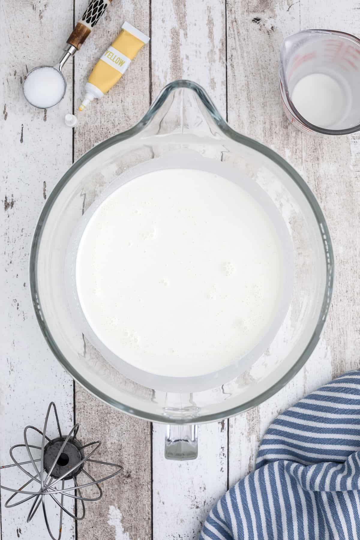 Heavy cream in a mixer bowl.