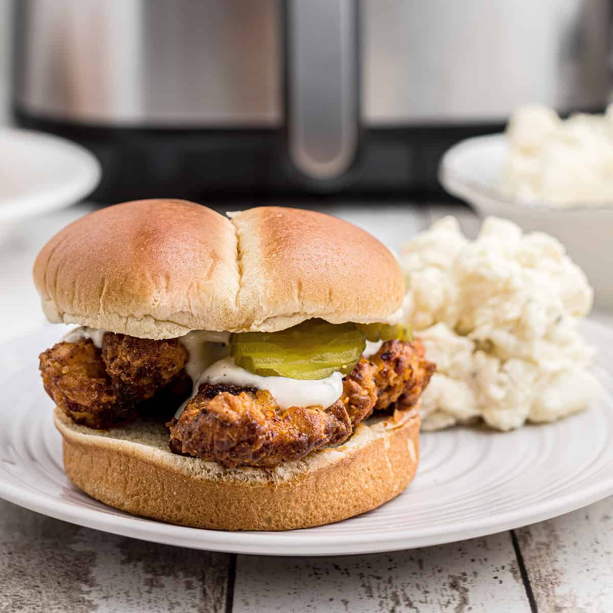 Nashville hot chicken sandwich on a white plate.