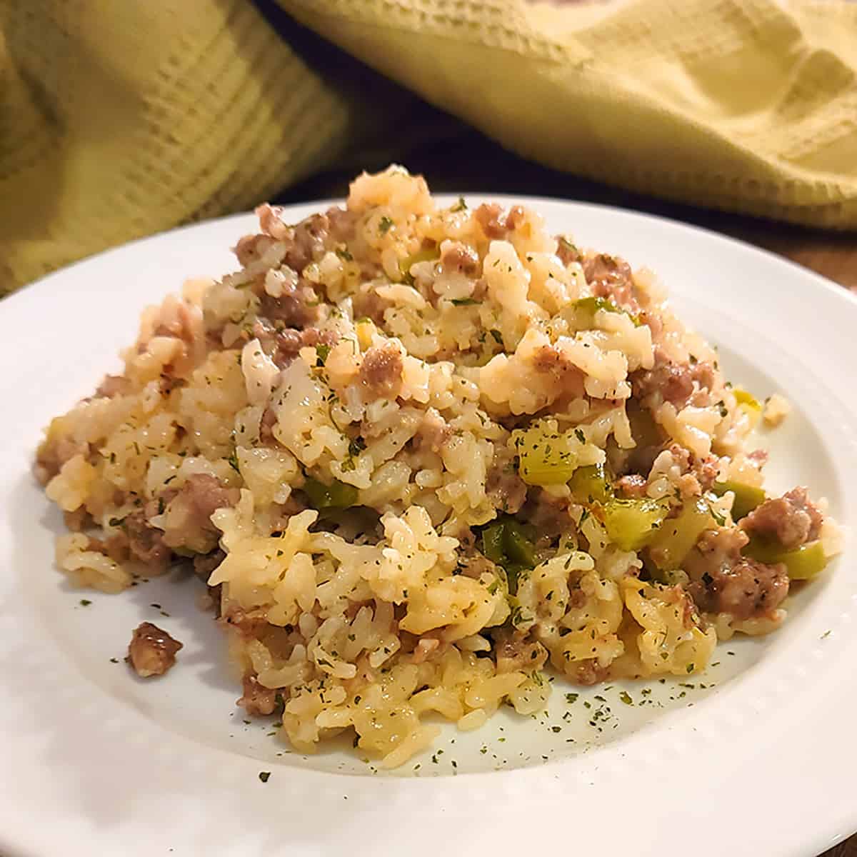 A serving of sausage rice casserole on a white plate.