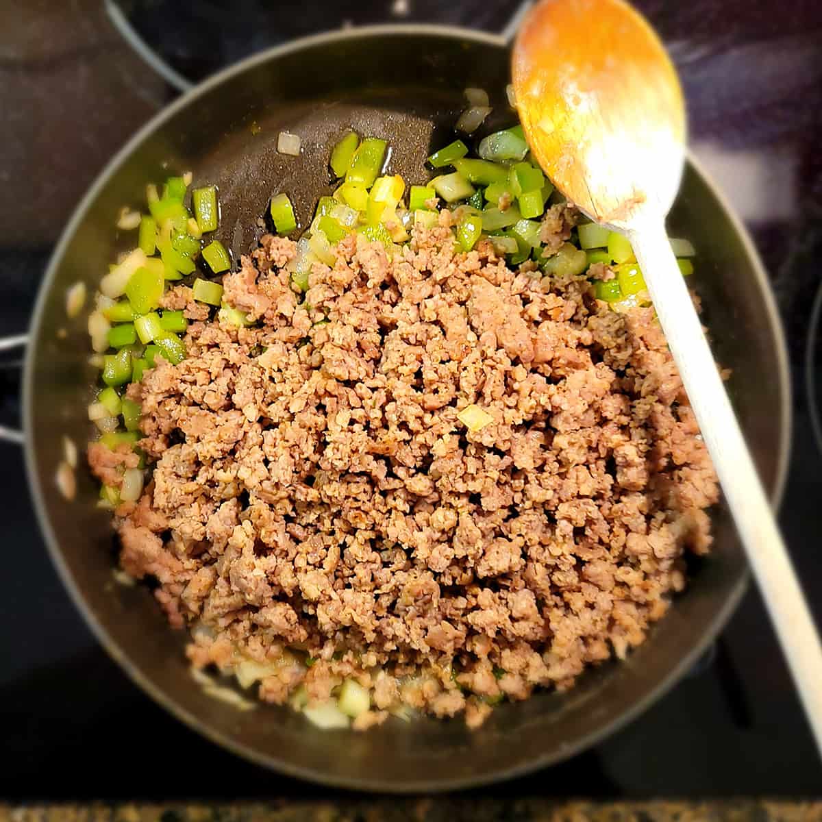 Browned sausage added back to skillet with cooked vegetables.