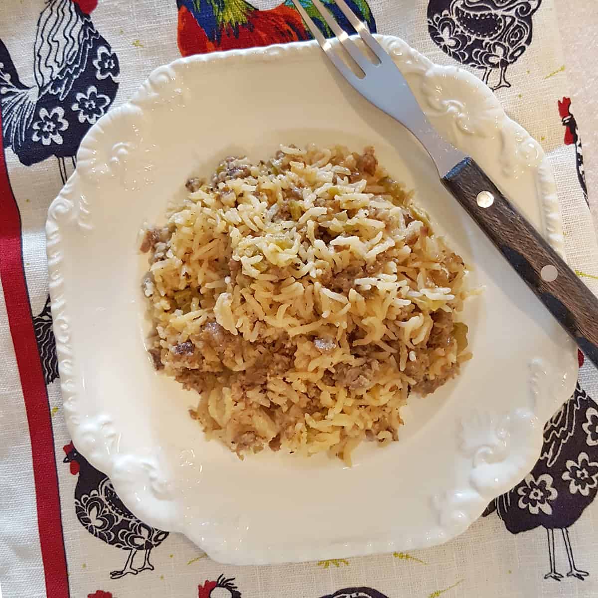 A serving of sausage rice casserole on a white plate.