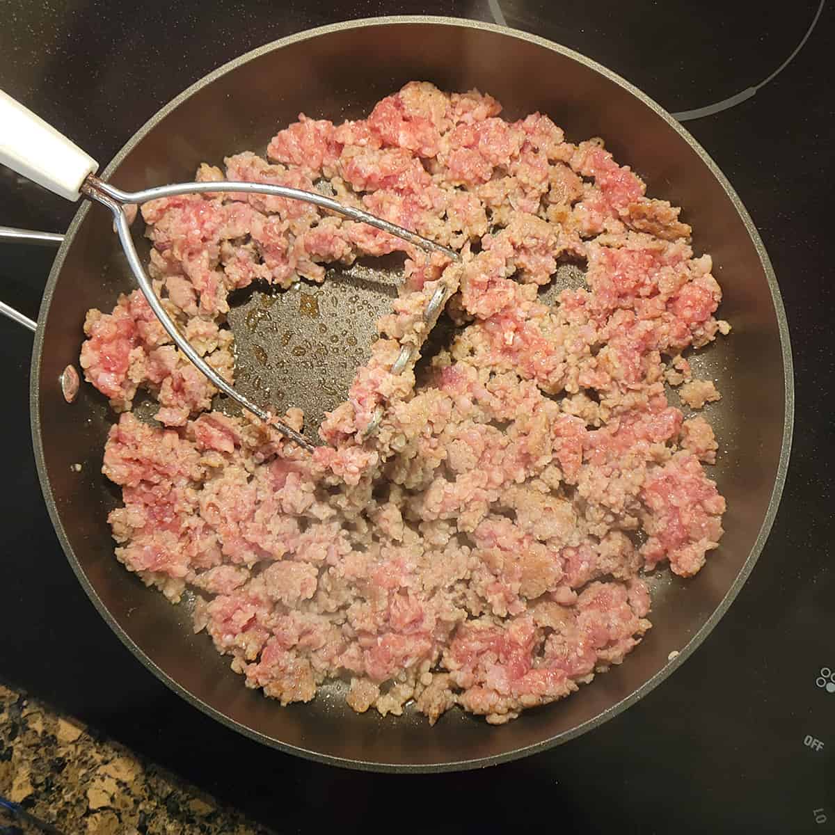 Sausage cooking in a skillet.
