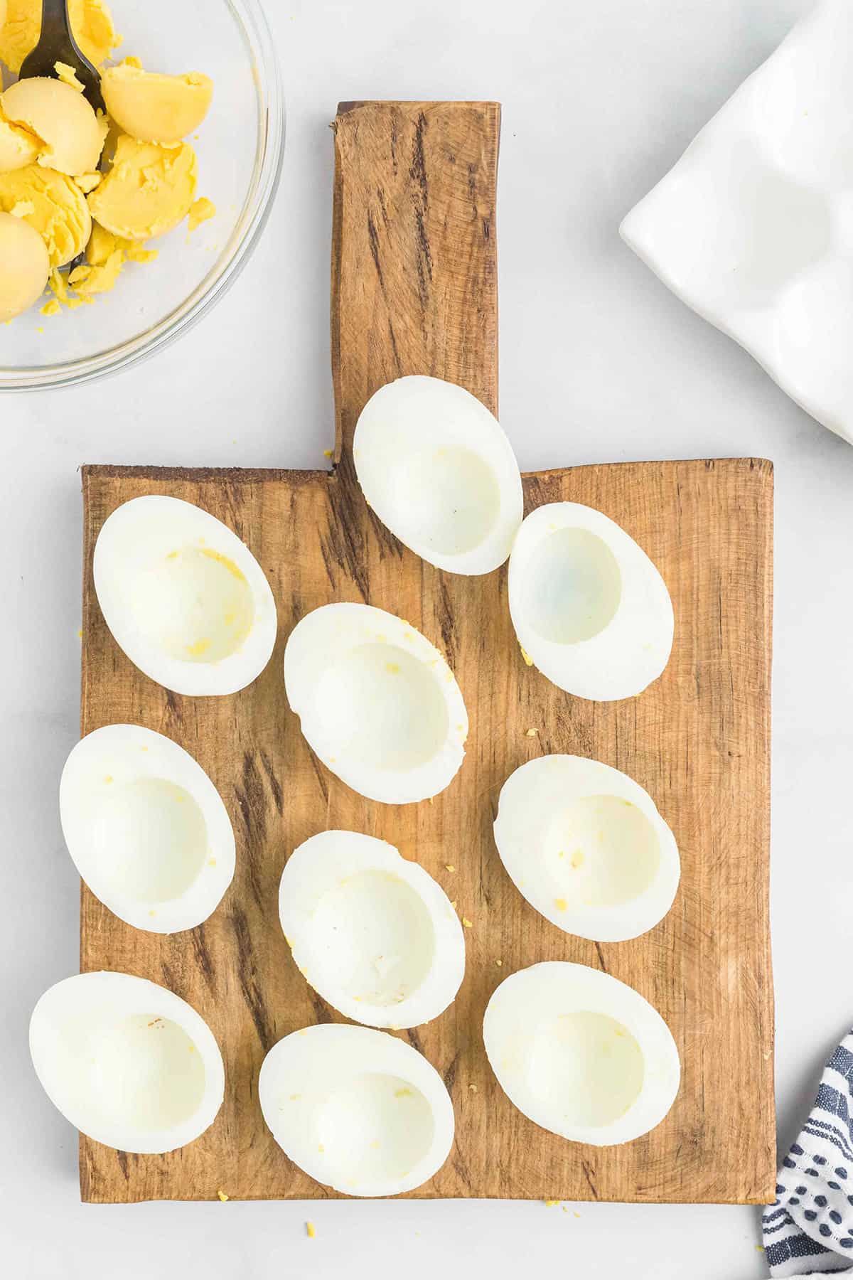 Egg white halves on a wooden board.