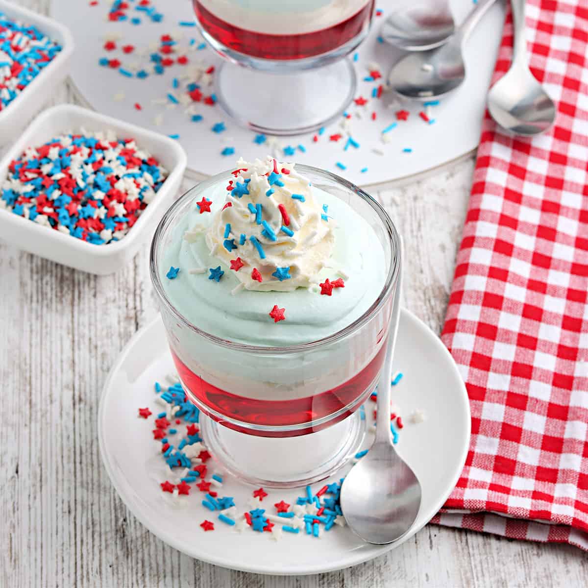 Finished red, white, and blue jello parfaits with sprinkles.
