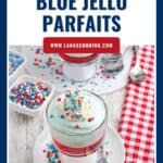 Red, white, and blue jello parfaits topped with whipped cream and star sprinkles, served with spoons.