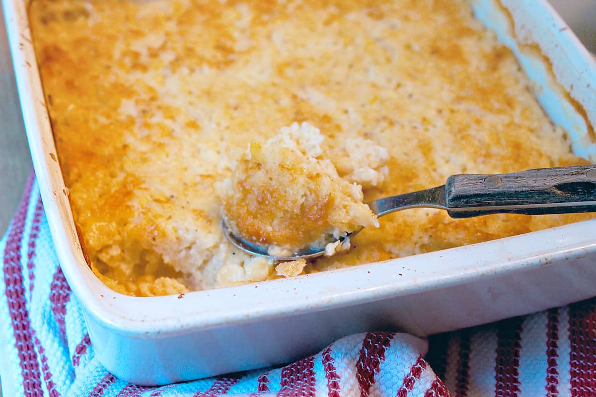 Finished baked corn casserole in a white baking dish.