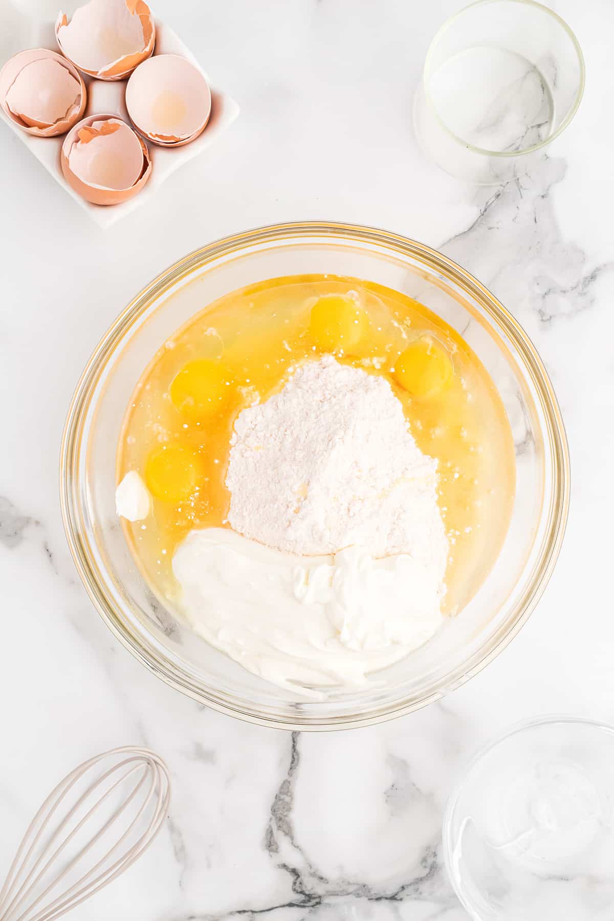 Cake mix, eggs, oil, and sour cream in a mixing bowl.