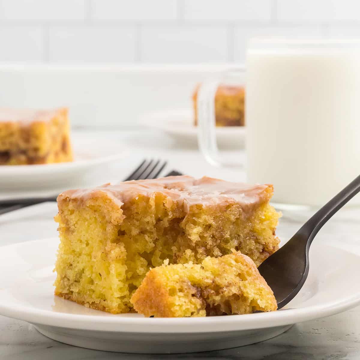 A serving of homemade honey bun cake on a white plate.