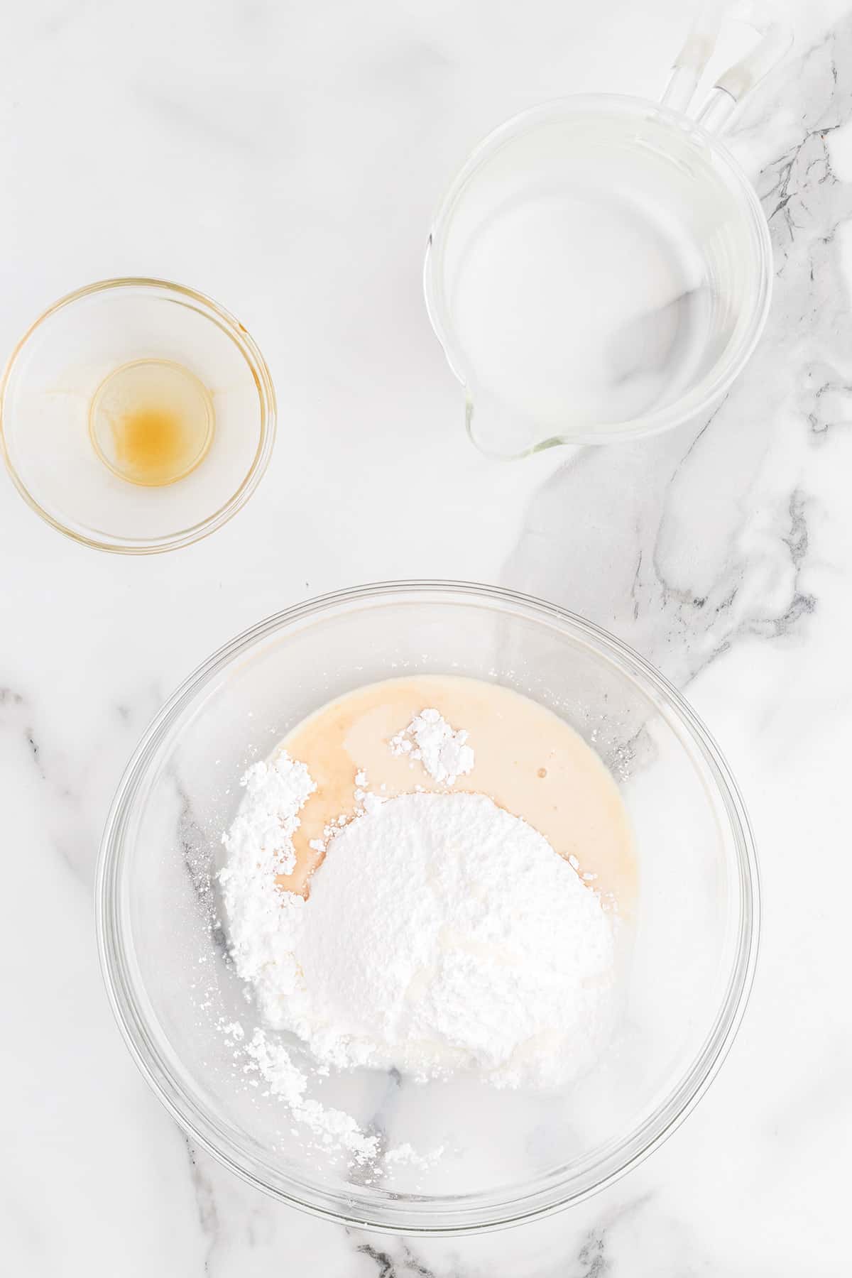 Powdered sugar, milk, and vanilla in a bowl.