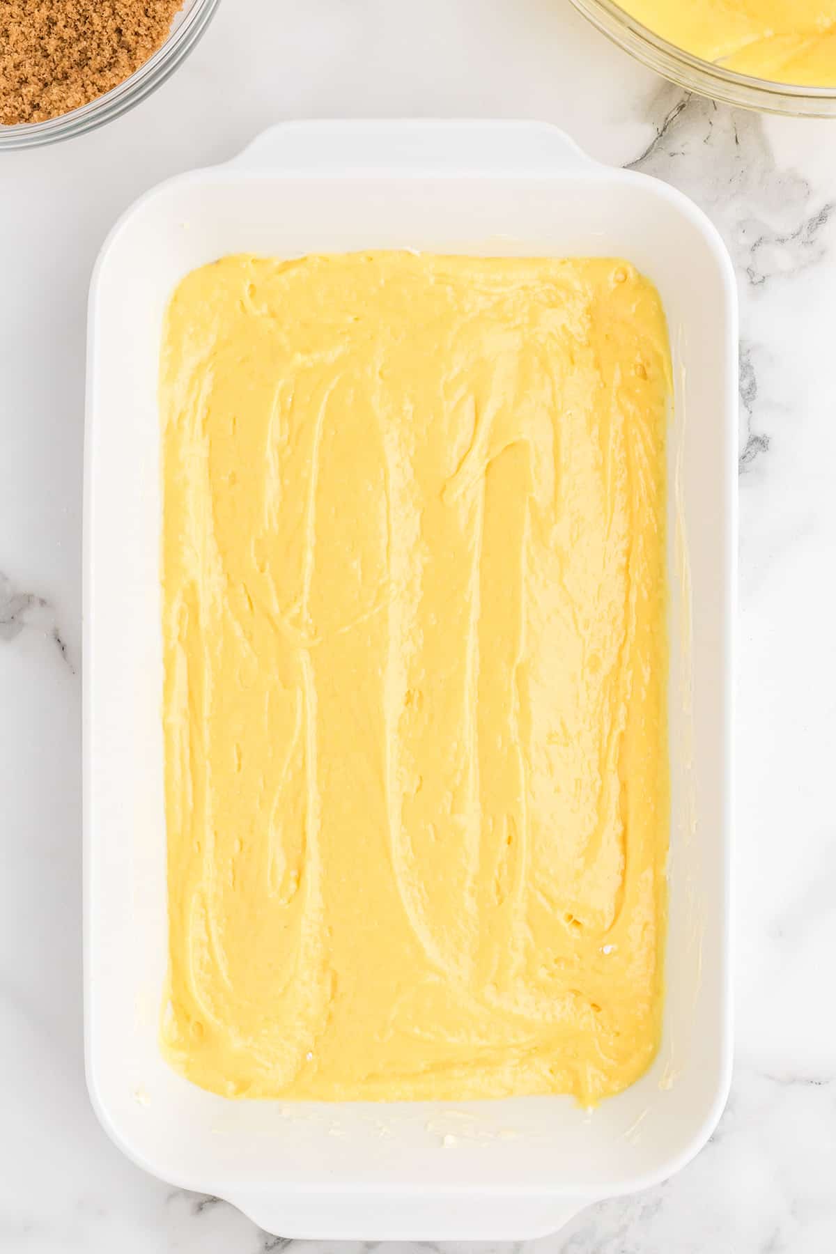 Half of the cake batter in a baking pan.