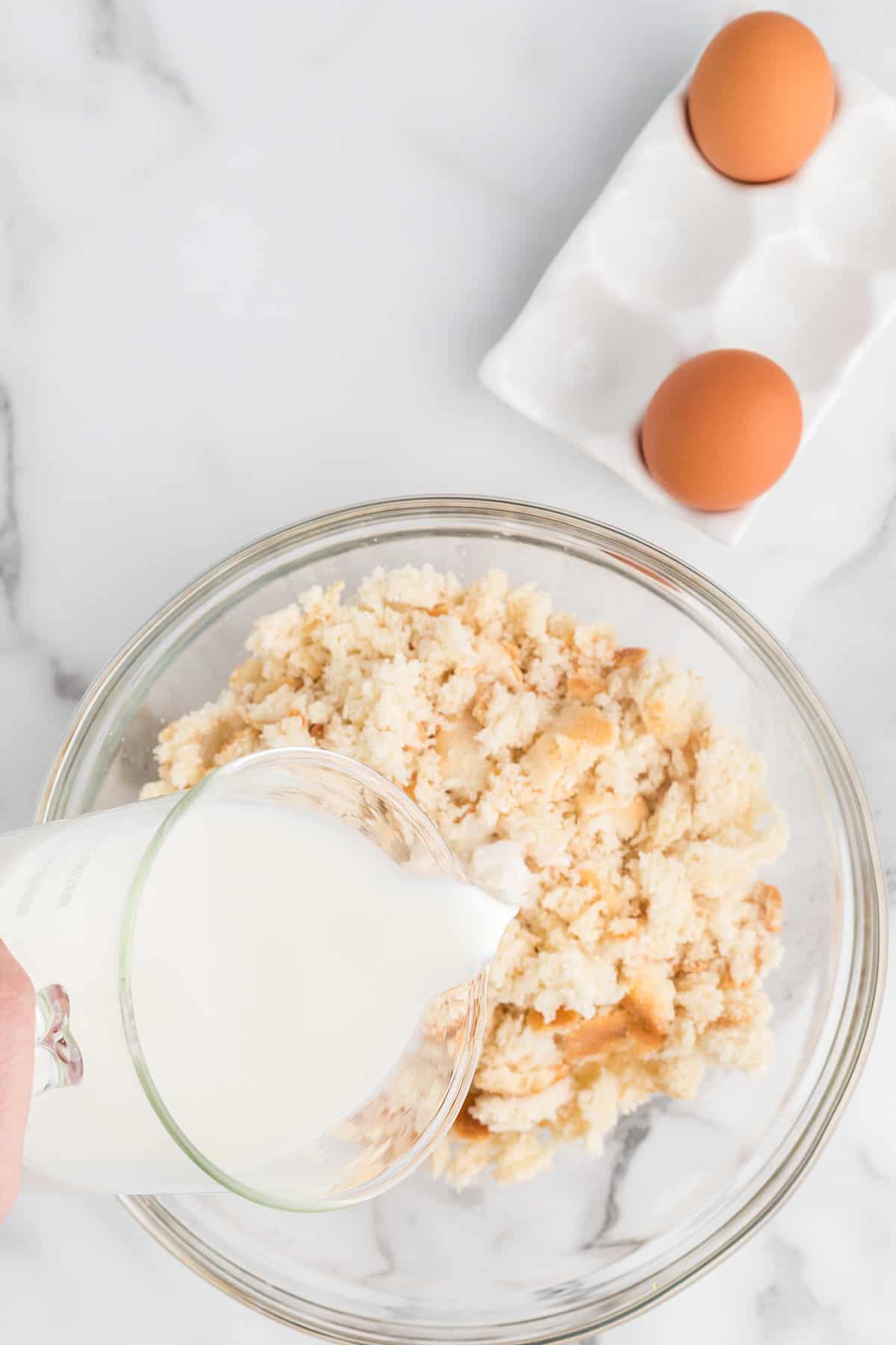 Adding milk to crumbled biscuits.