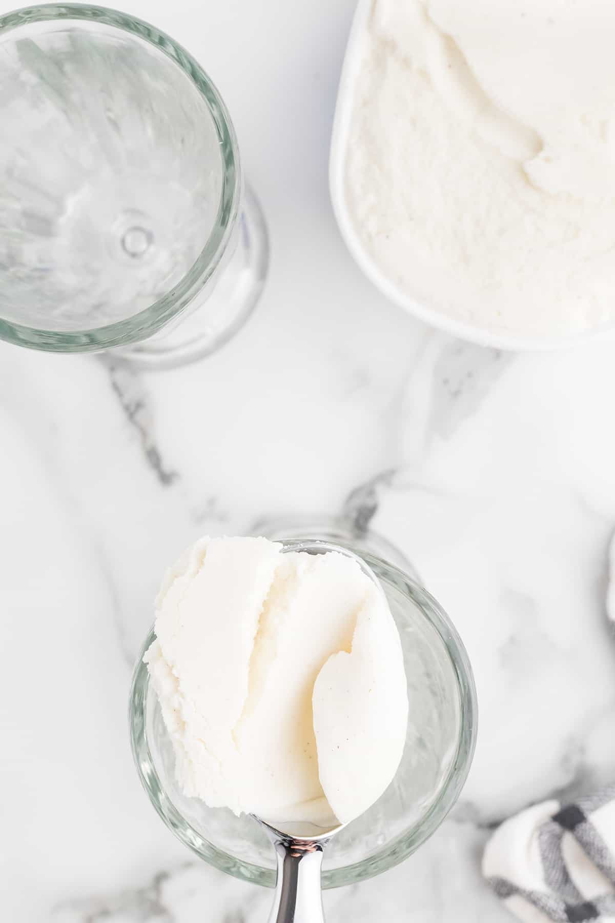 Scooping ice cream into soda glasses.