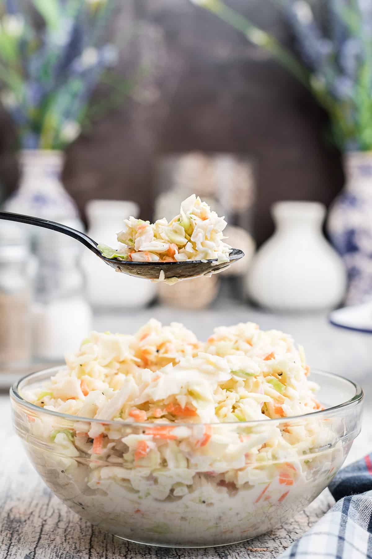 A glass serving bowl filled with coleslaw.