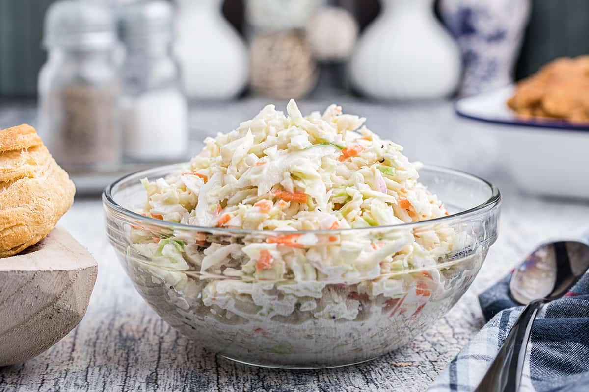 A glass serving bowl filled with coleslaw.