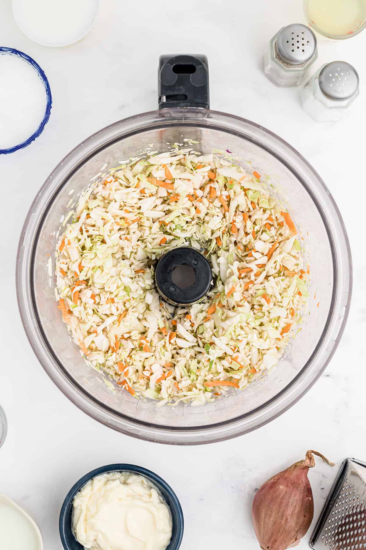 Coleslaw cabbage mix in a food processor bowl.