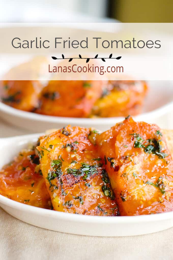 Garlic fried tomatoes in a small white serving bowl.