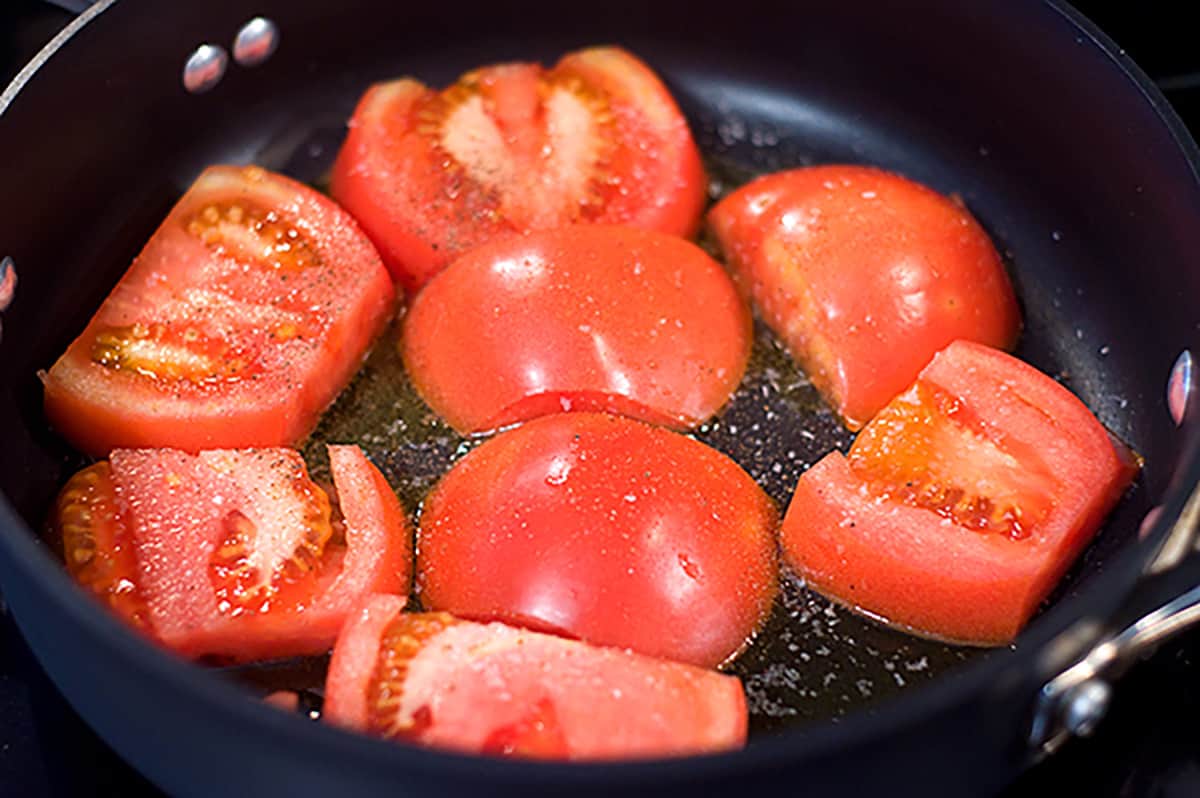Sliced tomatoes in a skillet.