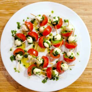 Finished mini caprese skewers on a white plate.