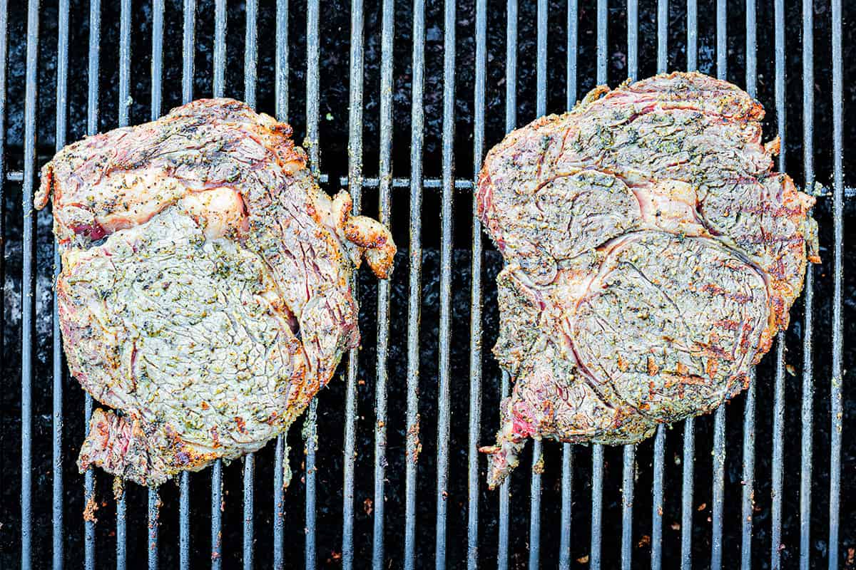 Two ribeye steaks on a grill.