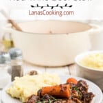 Beef stew on a plate alongside mashed potatoes.