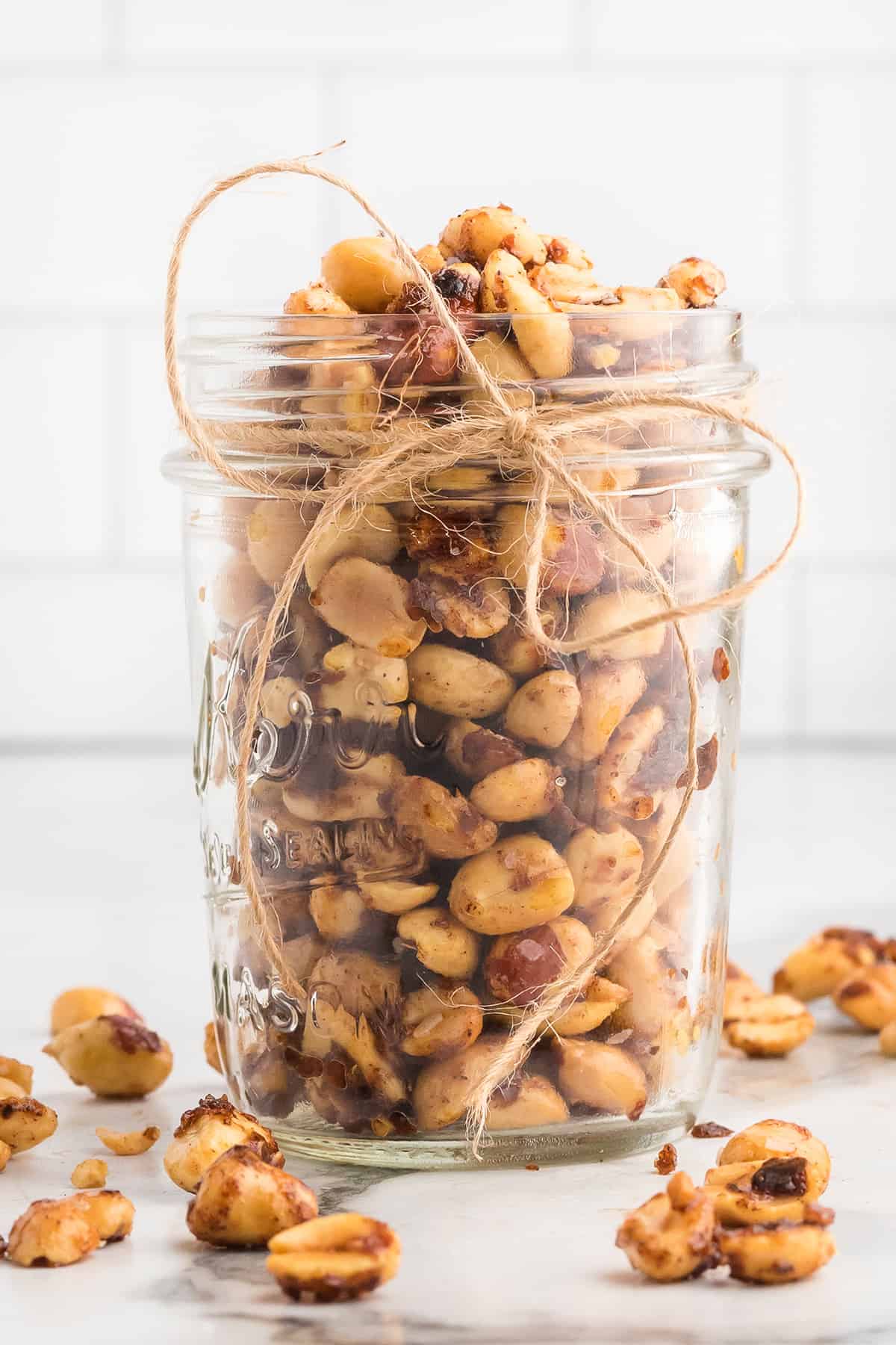 Finished peanuts in a mason jar with string tied around the top.