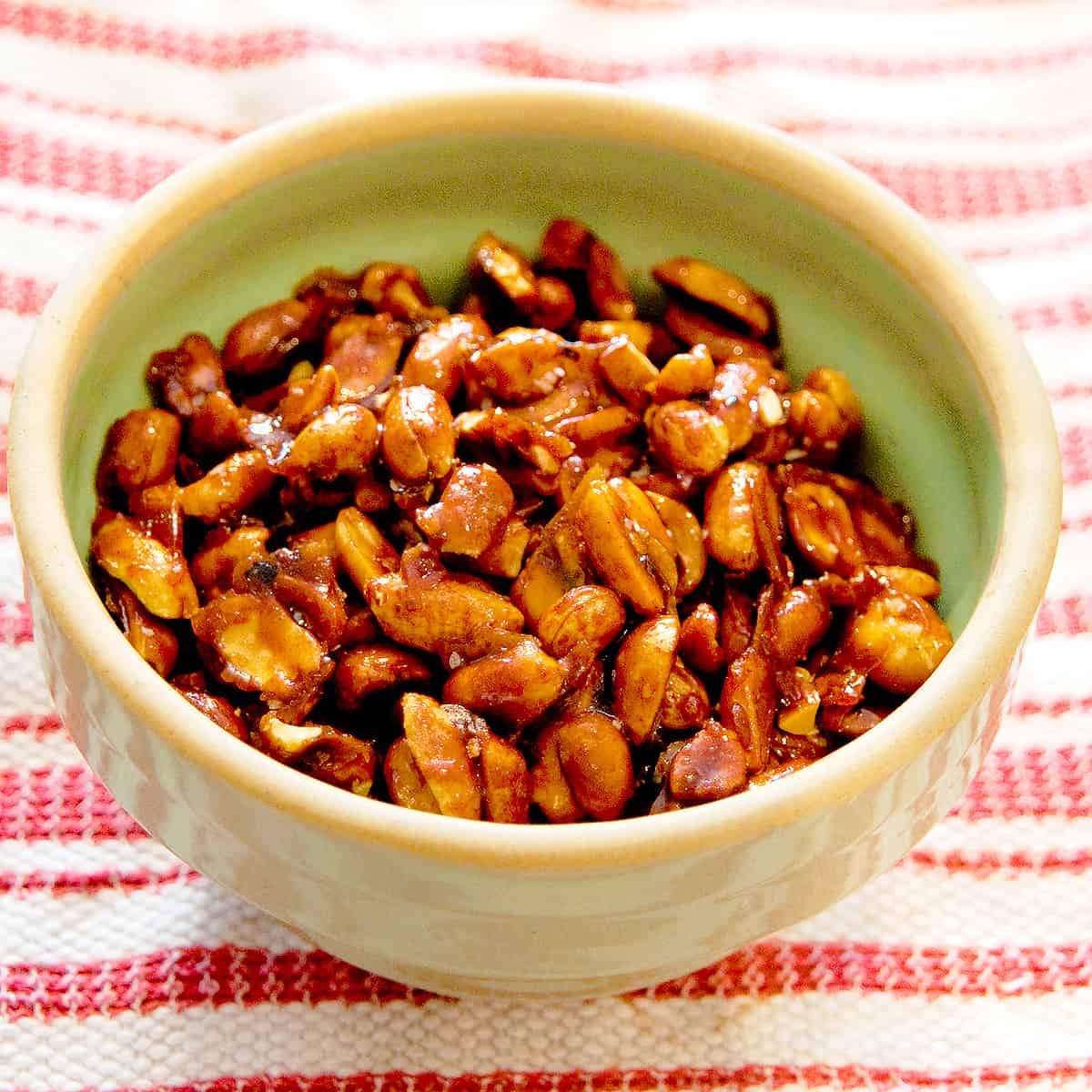 Finished peanuts in a small green bowl.