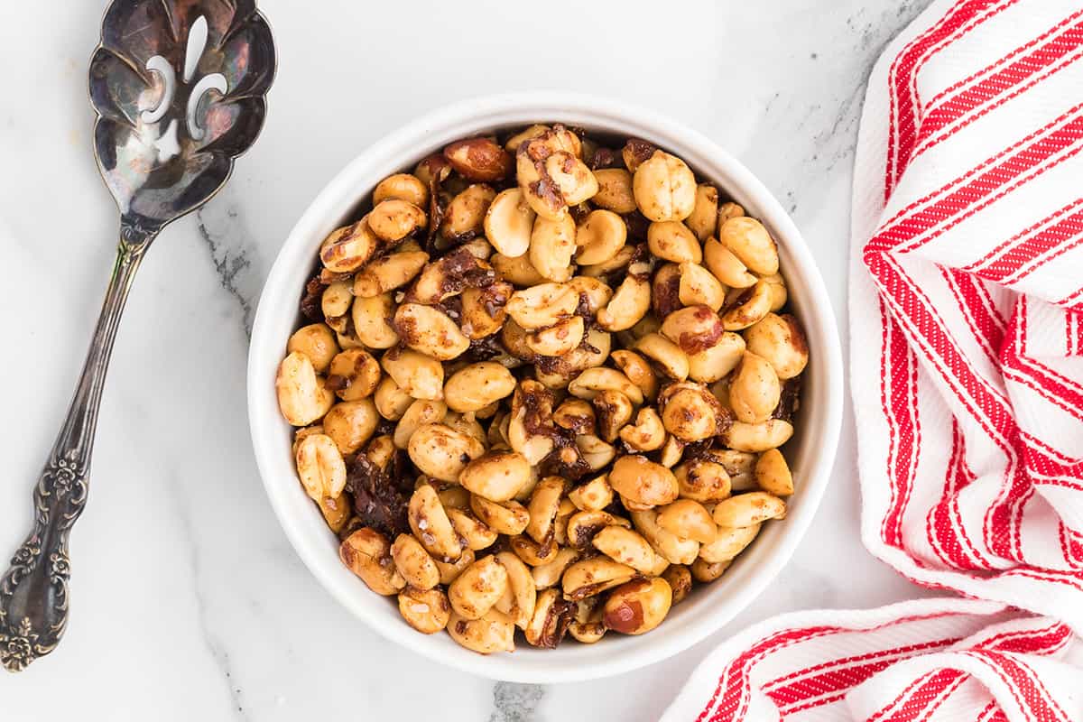 Finished peanuts in a bowl with a vintage serving spoon on the side.