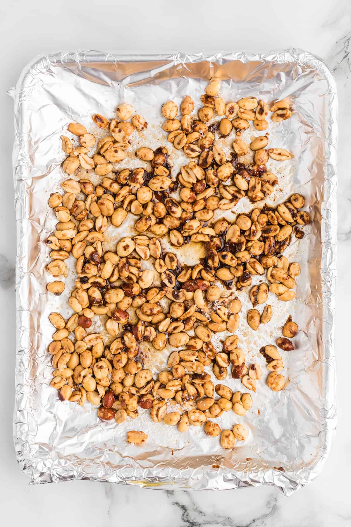 Peanuts spread on a pan covered with foil.