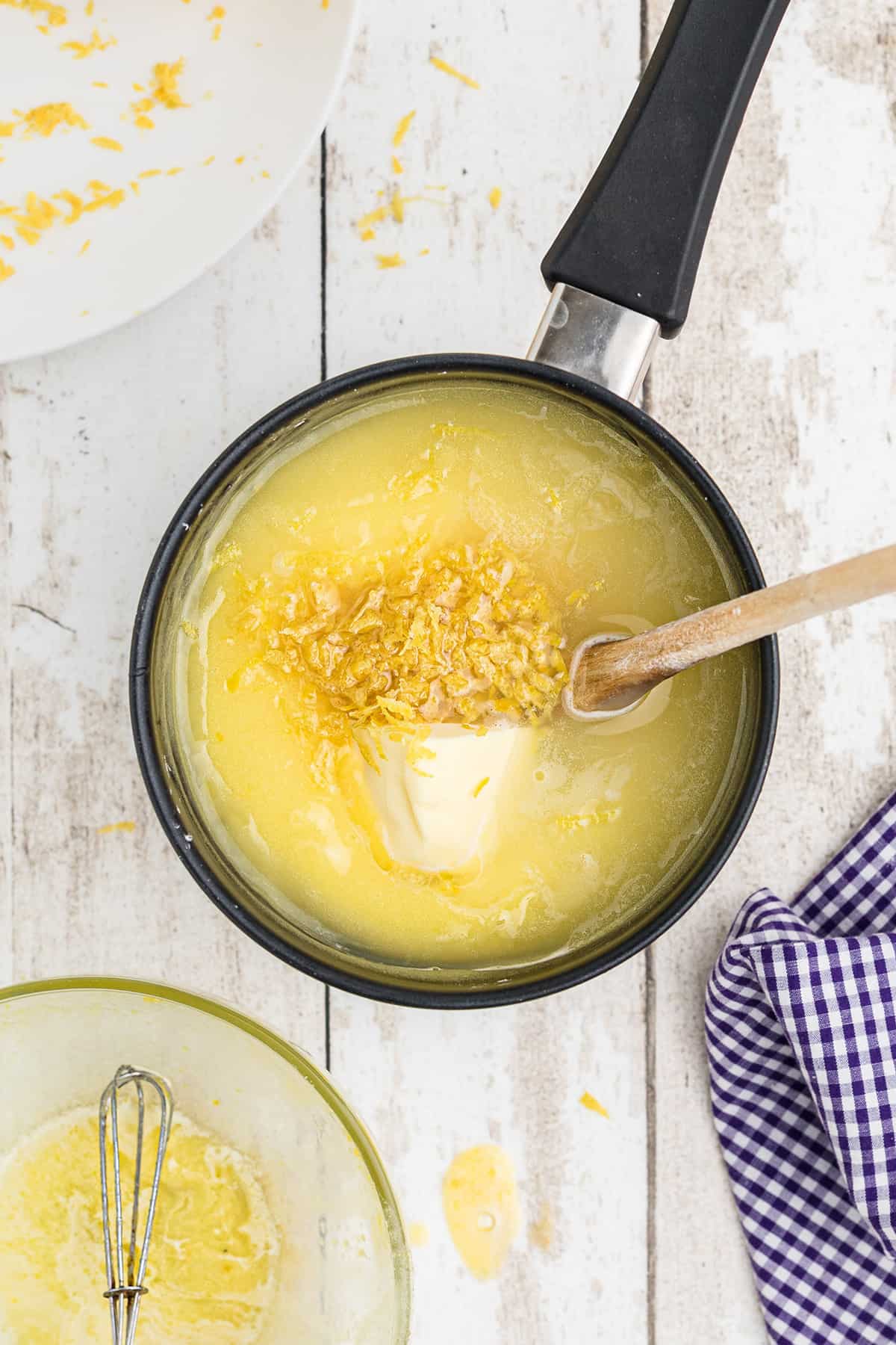 Adding butter and lemon zest to the mixture.