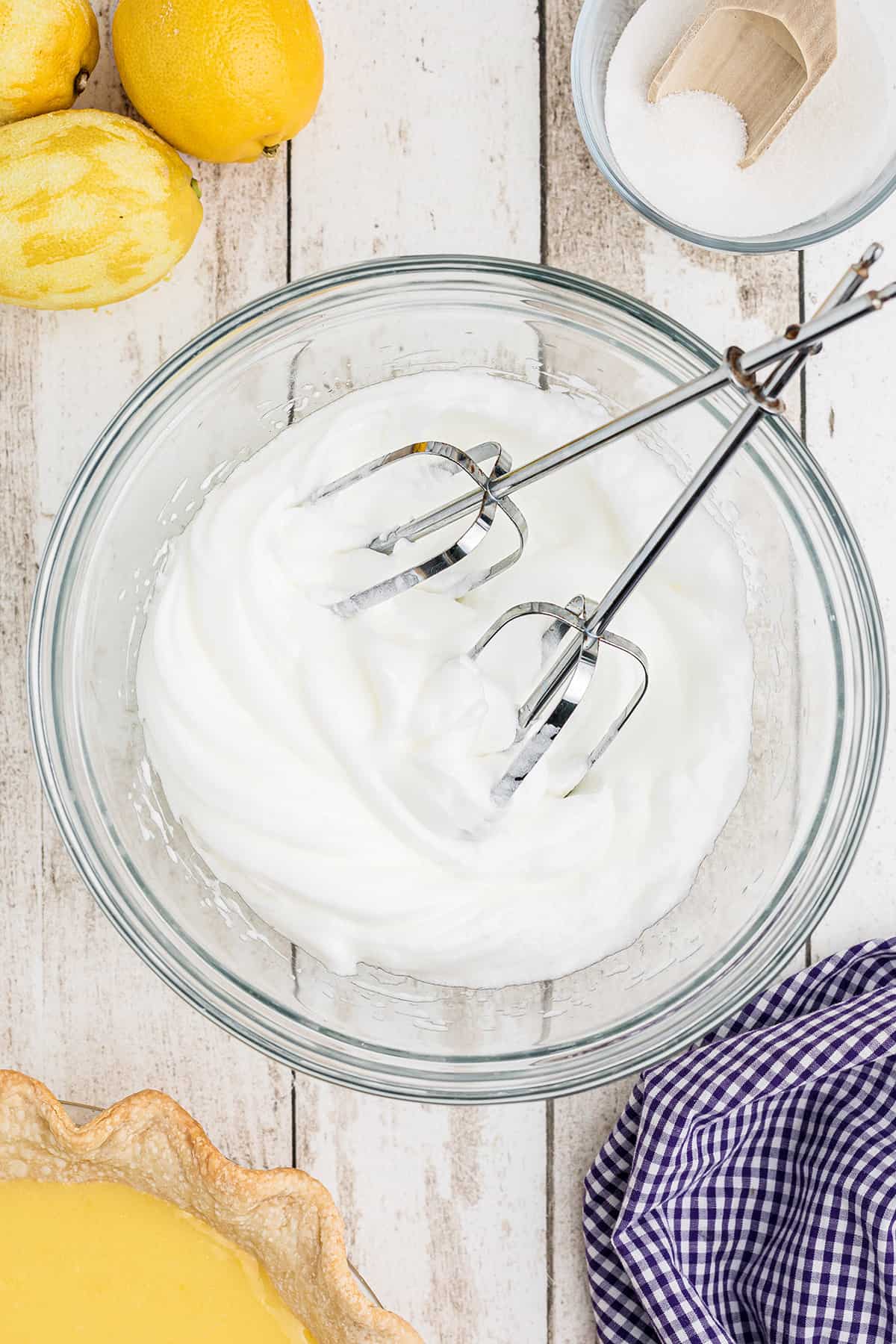 Egg white meringue in a bowl with mixer beaters.