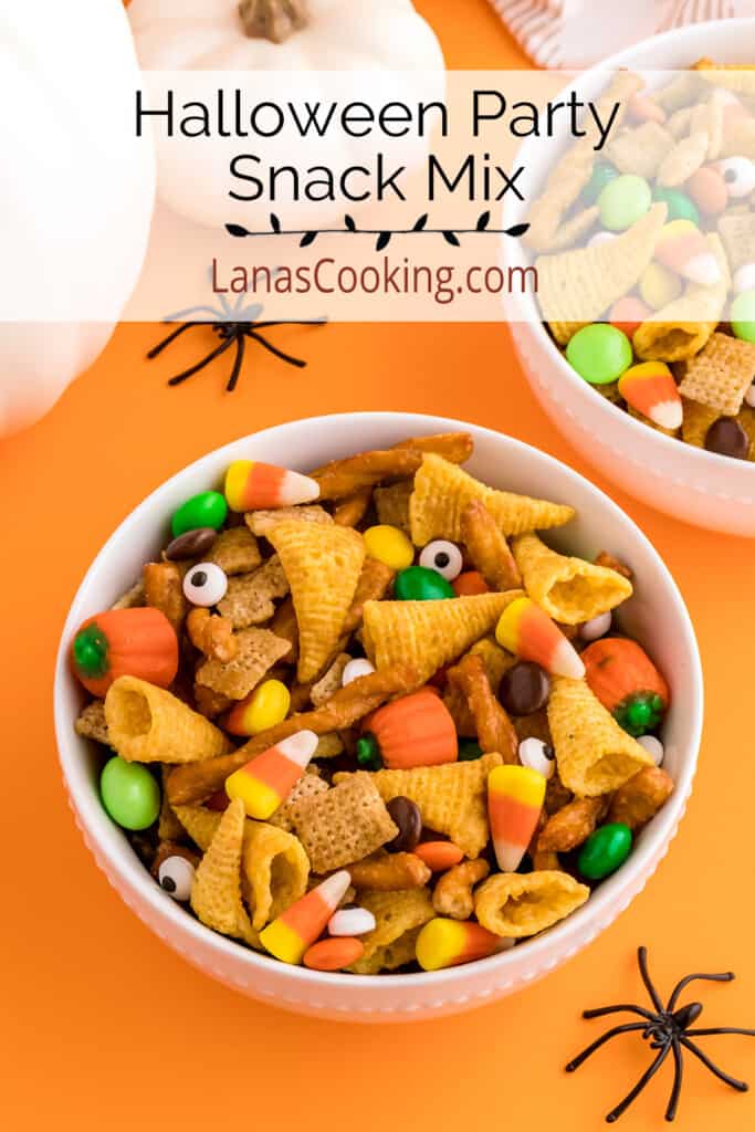 A white bowl filled with snack mix sitting on an orange background.