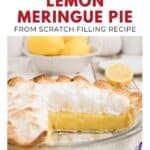 A lemon meringue pie with a golden crust and fluffy meringue, with lemons in the background.