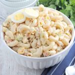 Finished macaroni salad in a white serving bowl.
