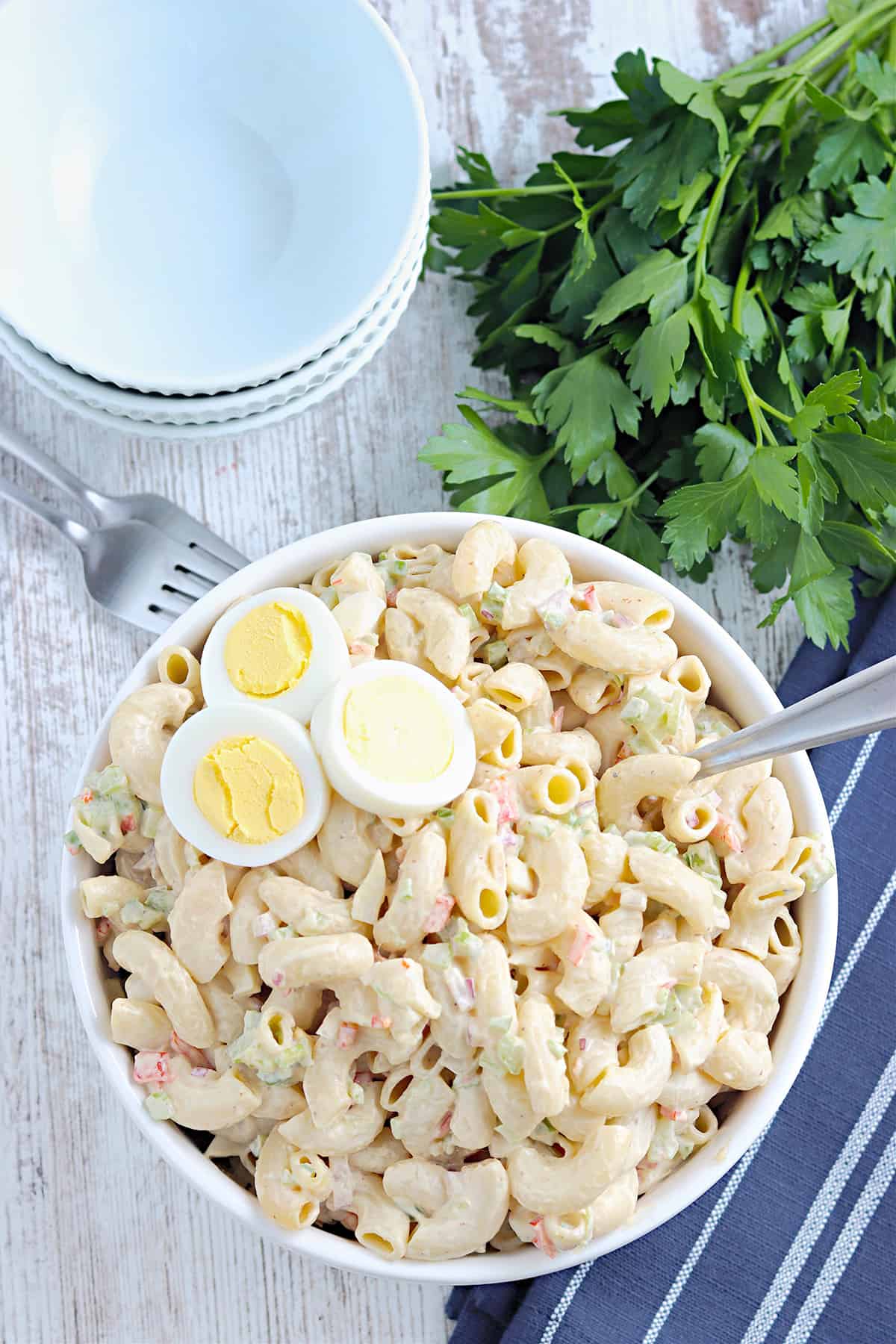 Finished macaroni salad in a white serving bowl.