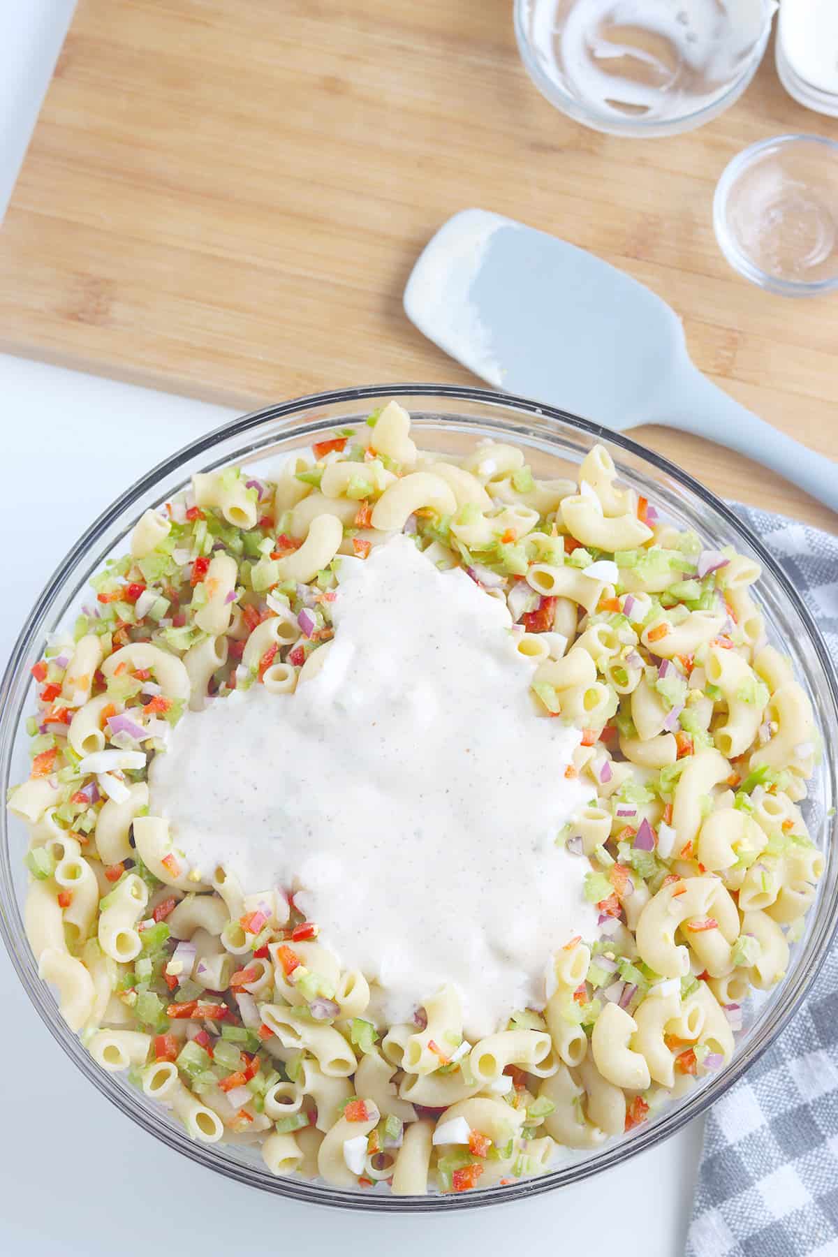 Dressing added to salad ingredients in the large mixing bowl.