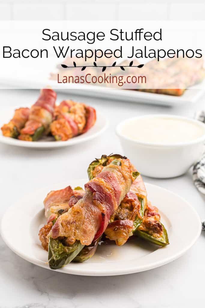 Bacon wrapped jalapeno poppers on a serving platter with a bowl of ranch dressing on the side.