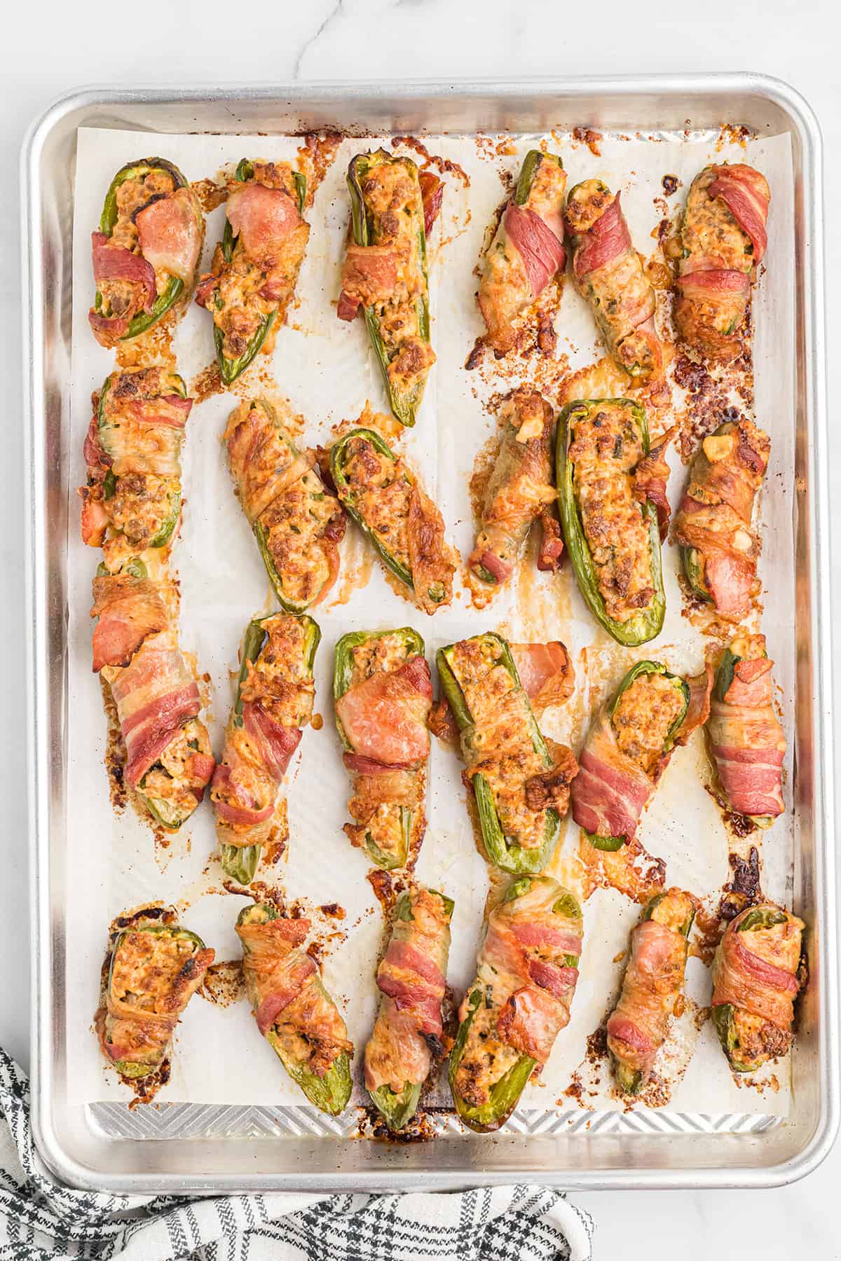 Cooked jalapeno poppers on a baking tray.
