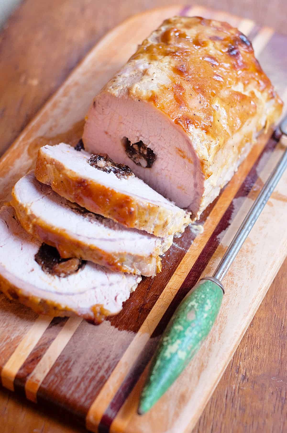 Cooked stuffed pork loin on a cutting board.