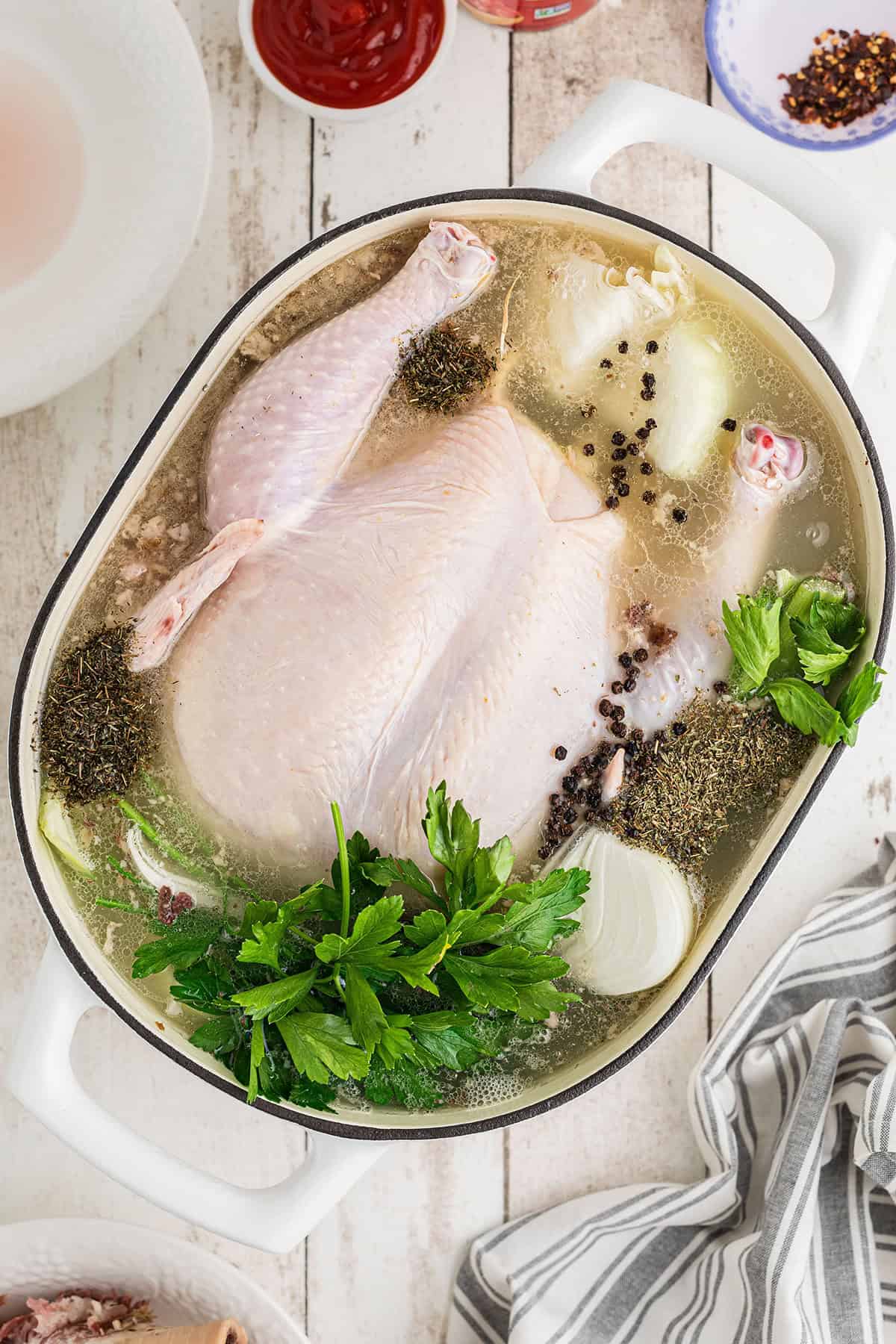 Stewing hen in a pot with water and aromatics.