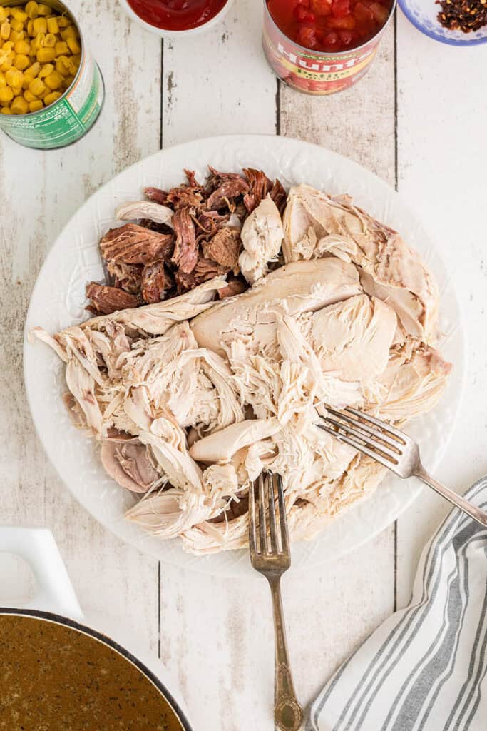 Shredding the chicken meat and smoked ham from the bone.