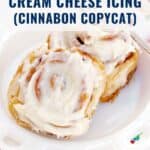 Two cinnamon rolls with cream cheese icing on a white plate, text above reads Cinnamon Rolls with Cream Cheese Icing.