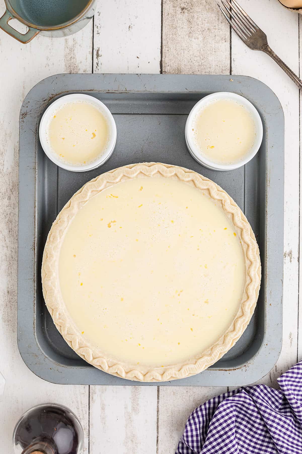 Pie crust and custard cups filled with egg and milk mixture.