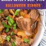 A bowl of beef stew with chunks of beef, onions, tomatoes, and herbs. The image is overlaid with text that reads Garlic Lover’s Beef Stew Halloween Dinner and decorated with spider web graphics.
