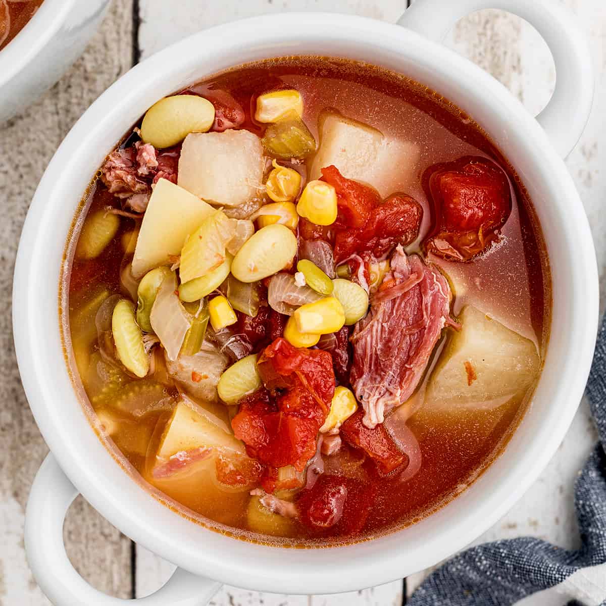 A white bowl filled with ham bone soup.